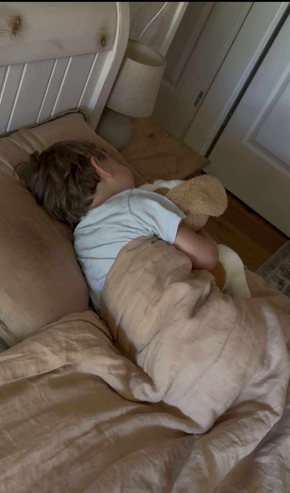 Kind slaapt rustig in bed met de Kyendo RustHond tegen zich aan